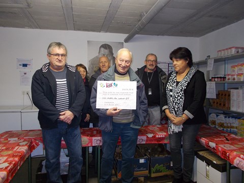 Remise du chèque aux Restos du Coeur sous la présence du président de l'association Pierre Le François et de bénévoles